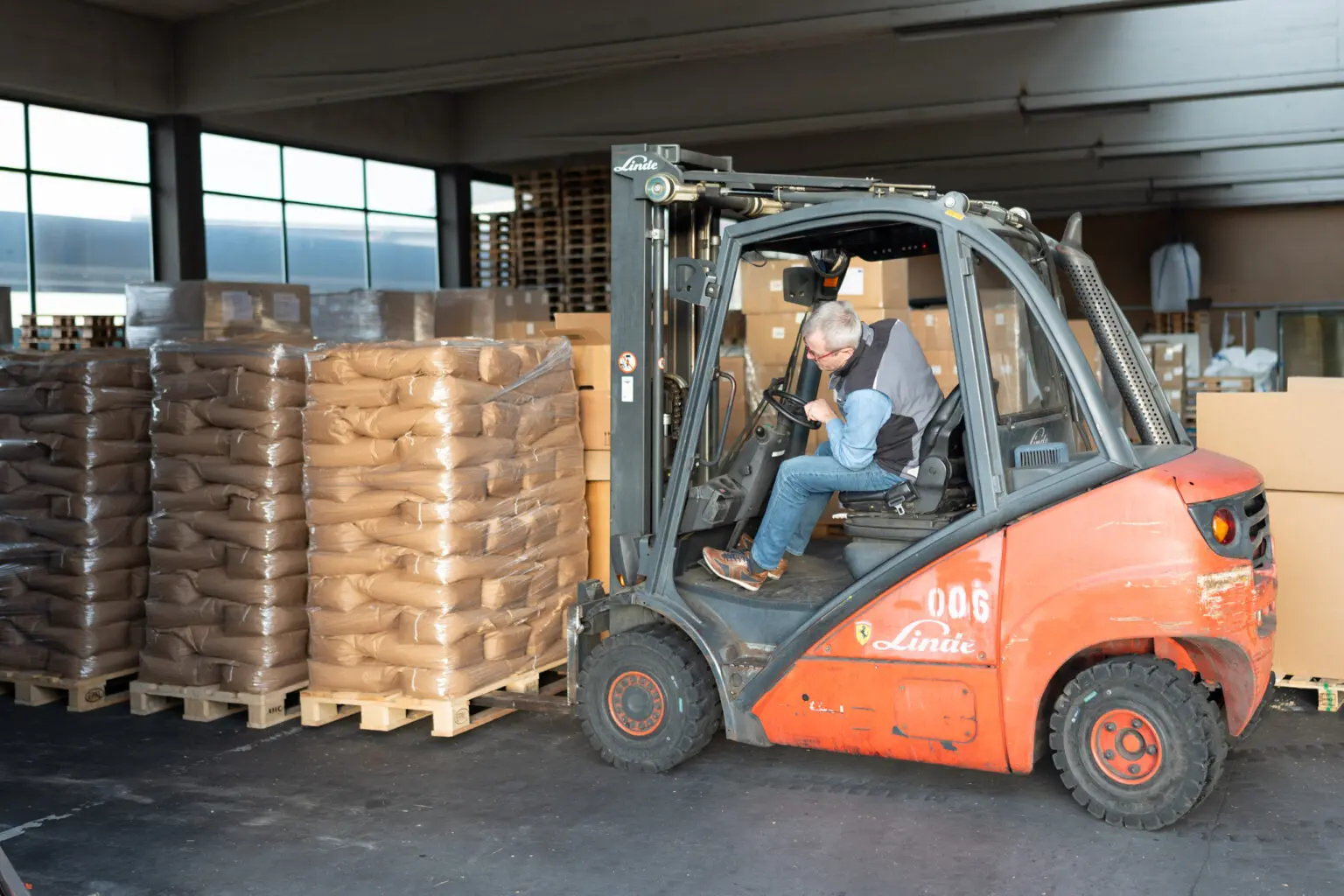 Gabelstapler bewegt eine Palette mit Papiersäcken im Lager.