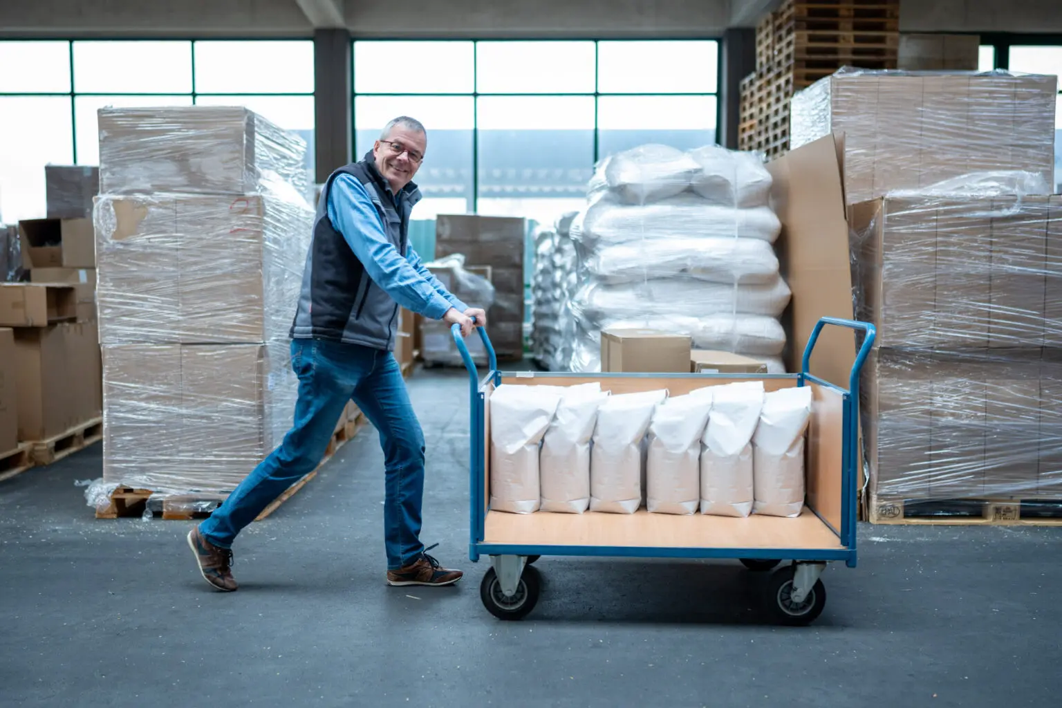 Mitarbeiter schiebt einen Wagen mit abgepackten Füllstoffen.